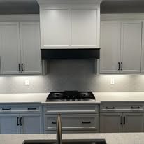 Kitchen with dark gray shaker cabinets and black range hood