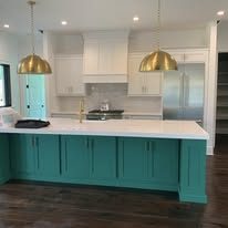 Kitchen with teal painted island and white cabinets