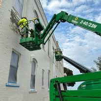 Crew on a lift painting a downtown commercial storefront