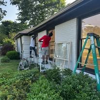 Crew painting the brick exterior of a ranch home
