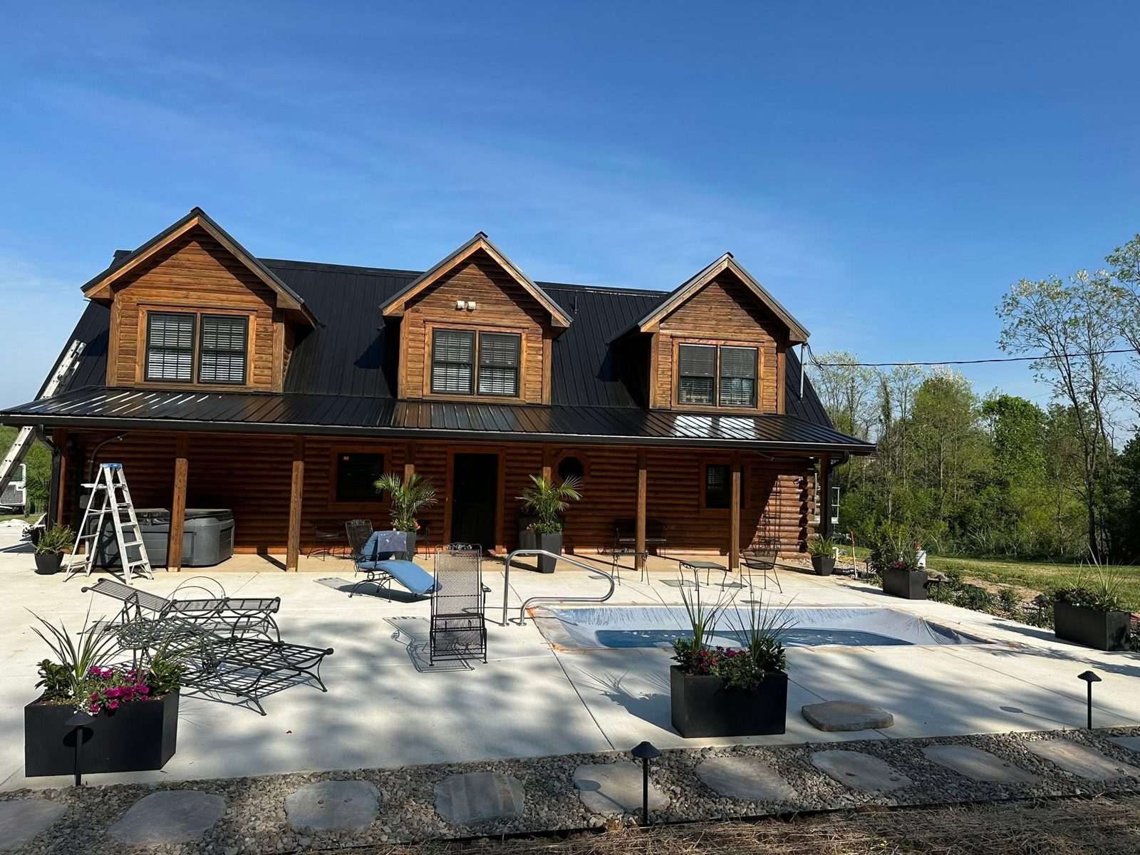 Log cabin exterior stain job with pool deck