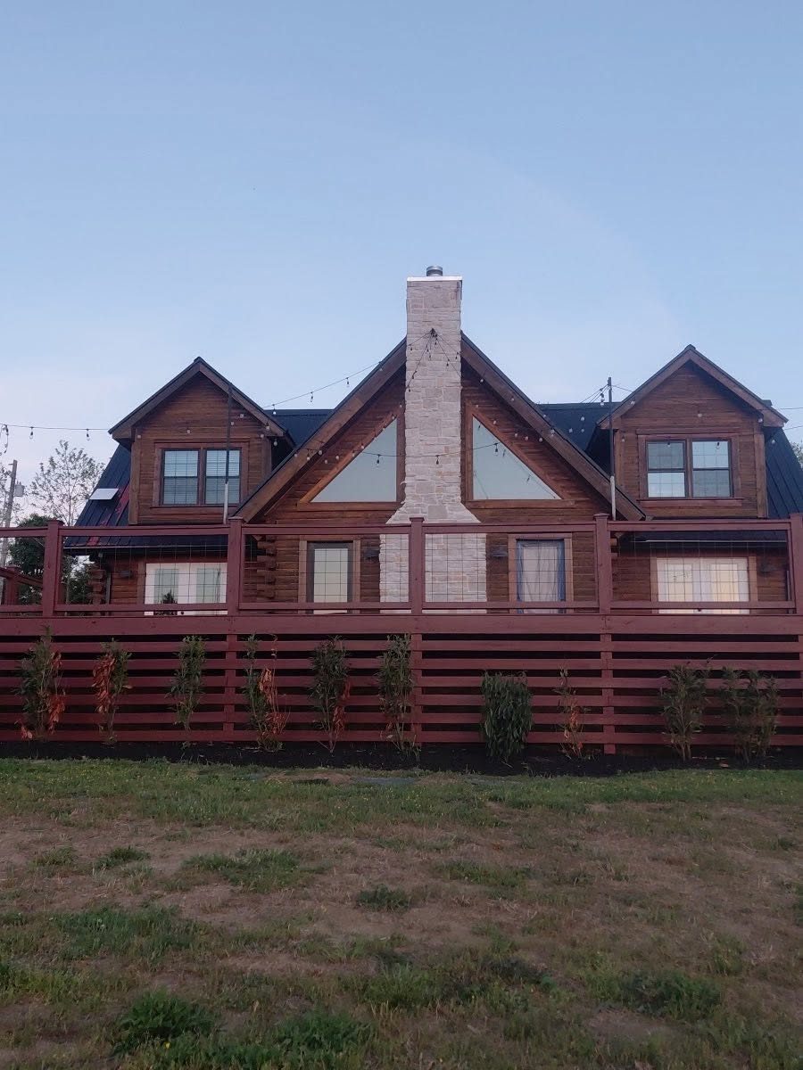 Log home exterior stain, red trim and dark roof