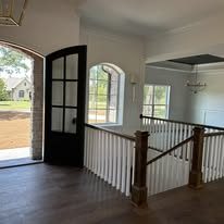 Entryway with black French doors and staircase