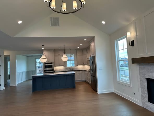 Kitchen with vaulted ceiling and fireplace beyond
